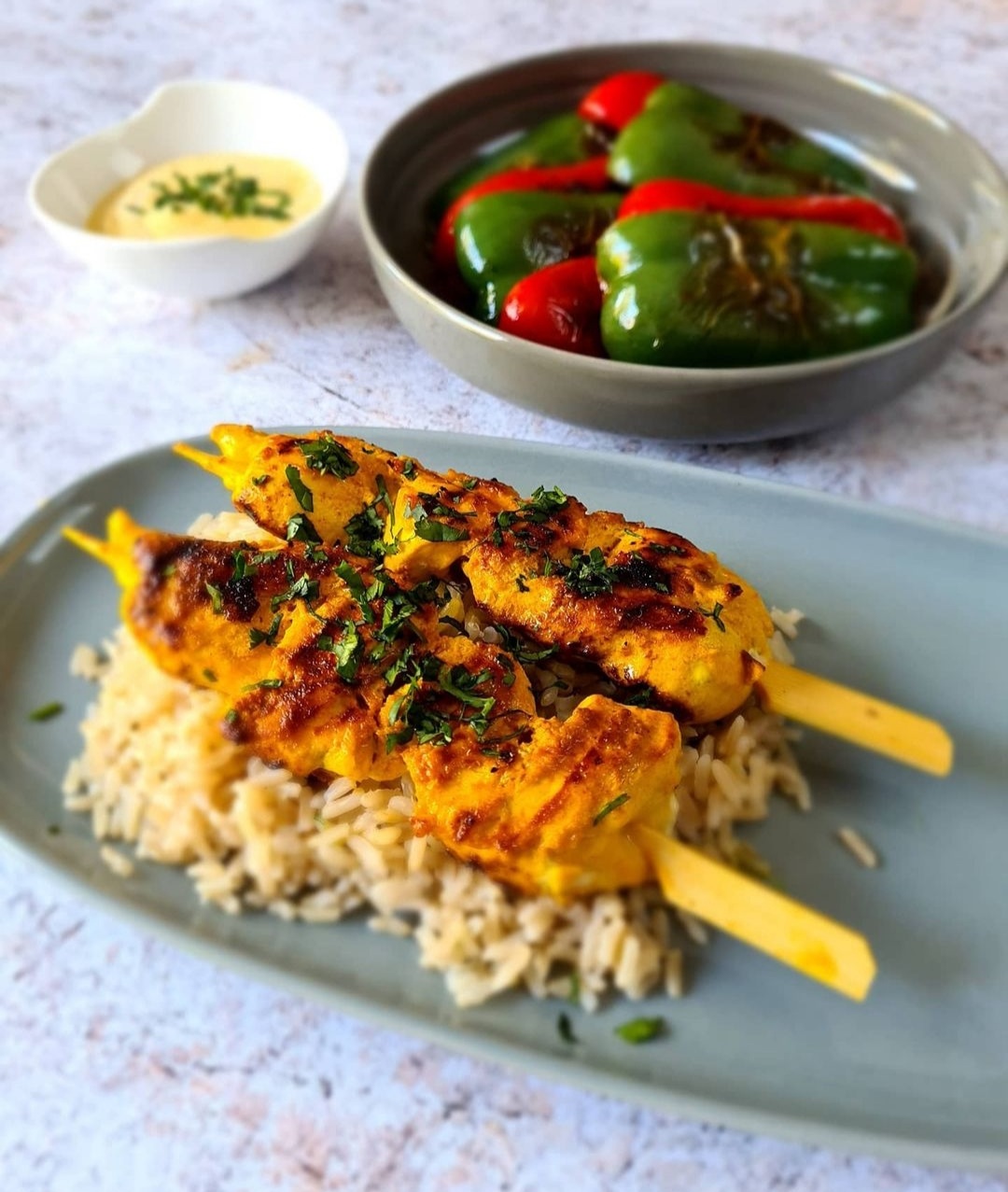 Turmeric and garlic chicken kebabs, charred peppers, brown rice and turmeric dipping yoghurt